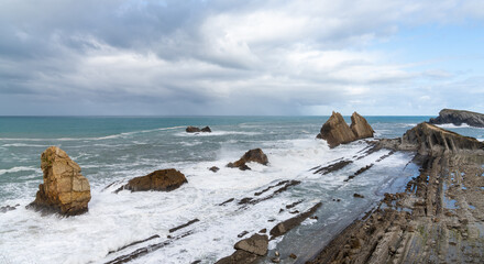 Sticker - rocky and wild coast with stormy waves hitting the shore