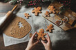 Christmas gift gingerbread on dark background. Woman is holding Christmas gingerbread cookies with icing sugar. Top view

