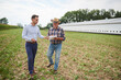© Anna Bizon/Westend61 - Farmer and businessman discussing data from clipboard on the field