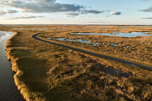 USA, Maryland, Drone View Of Road Stretching Across Marshes Along Blackwater River At Dusk