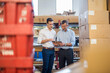 © Daniel Ingold/Westend61 - Two businessmen in factory storeroom looking at tablet