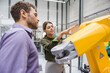 © Daniel Ingold/Westend61 - Businessman and woman having a meeting in front of industrial robots in a high tech company