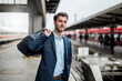 © Daniel Ingold/Westend61 - Smiling businessman with bag at the platform