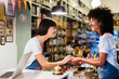 © BONNINSTUDIO/Westend61 - Two happy women at the counter in a store