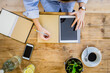 © Giorgio Fochesato/Westend61 - Top view of woman at wooden desk with notebook, cell phone and tablet