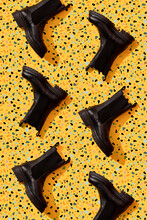 Black Leather Boots On Yellow Terrazzo Pattern