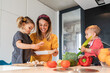 © Juan Miguel Aparicio/Westend61 - Mother and girl preparing food while baby daughter sitting on kitchen island