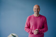 © Kniel Synnatzschke/Westend61 - Portrait of smiling mature man wearing pink pullover