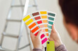 © Maria Maar/Westend61 - Woman holding colour sample in an empty room with a ladder