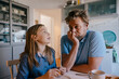 © Kniel Synnatzschke/Westend61 - Daughter talking to father in kitchen at home