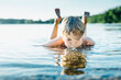 © Jana M√§nz/Westend61 - Boy in a lake blowing into water