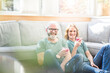 © Robijn Page/Westend61 - Happy mature couple with healthy drinks in living room at home