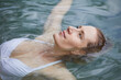 © philipp nemenz/Westend61 - Portrait of relaxed woman floating on water
