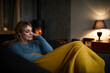 © Rainer Berg/Westend61 - Portrait of smiling woman relaxing on couch at home in the evening
