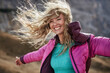 © philipp nemenz/Westend61 - Happy young woman leaning against the wind in the mountains