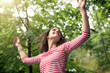 © philipp@nemenz.de/Westend61 - Happy young woman with raised arms dancing in nature
