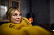 © Rainer Berg/Westend61 - Portrait of smiling woman relaxing on couch at home in the evening