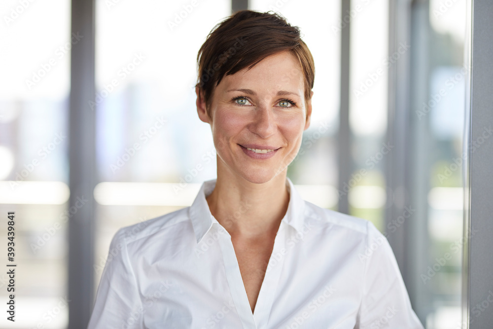 Portrait of smiling businesswoman in office Stock Photo | Adobe Stock