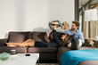 © steve brookland/Westend61 - Happy parents playing with son on sofa at home