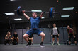 © SERGIO NIEVAS/Westend61 - Athletes cheering man picking barbell while standing at gym
