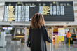© SERGIO NIEVAS/Westend61 - Young woman checking arrival timing of flight on board standing at airport