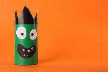 Funny Green Monster On Orange Background, Space For Text. Halloween Decoration