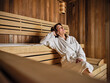 © Zeljko Dangubic/Westend61 - Senior woman with hands behind head relaxing in sauna at health spa
