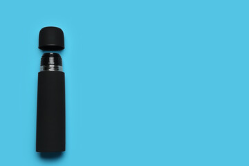 Wall Mural - Black thermos on light blue background, top view. Space for text