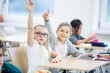 © Pavel Horak/Westend61 - Schoolgirls with tablet raising their hands in class