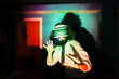 © Manu Reyes, www.vientocuatro.com/Westend61 - Smiling man wearing virtual reality glasses standing in multi colored light reflection at home during pandemic