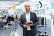 © Robijn Page/Westend61 - Thoughtful businessman holding digital tablet while looking away at illuminated factory