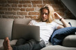 © Flamingo Images/Stocksy - Young man with laptop on couch