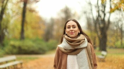 Wall Mural - smiling beautiful young woman enjoy autumn in a public park