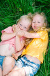 © Duet Postscriptum/Stocksy - Two blonde girls play lying in the grass.