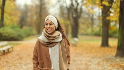 Wall Mural - smiling beautiful young woman enjoy autumn in a public park