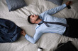 © New Africa - Exhausted businessman in office wear sleeping on bed at home after work, top view