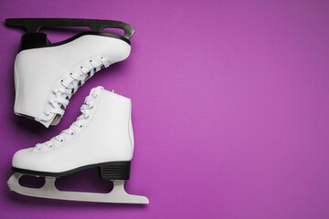 Wall Mural - pair of figure ice skates on purple background, flat lay. space for text