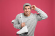 Happy man with ice skates on pink background