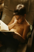 A Young Boy Reads A Book.