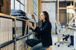 © Sofie Delauw/Stocksy - Female employee taking folder from shelf