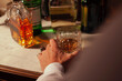 © FRANCESCO BITTICHESU/Stocksy - Young man's cropped hand holding a whisky glass.