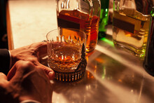 Young Man's Cropped Hand Holding A Whisky Glass.