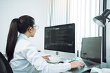 Fototapeta Panele - Asian woman professional development programming website working a software in office room.