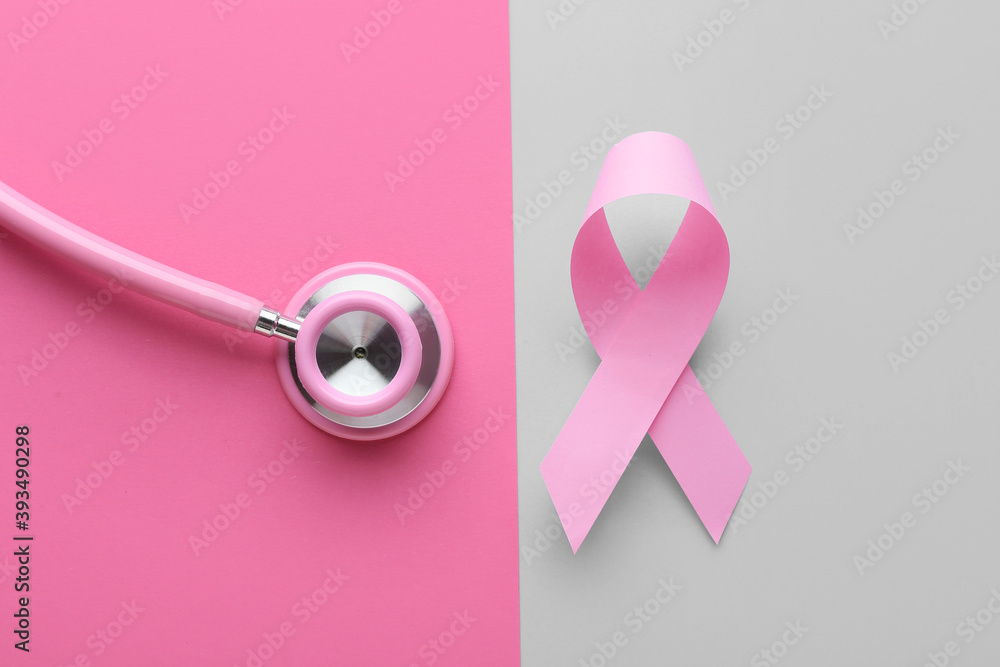 Pink ribbon and stethoscope on color background. Breast cancer awareness concept