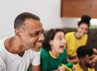 Wall Mural - real latin american family watching football on television, celebrating goal of brazil