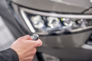 Wall Mural - Close-up of male hand pressing car alarm