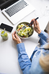 Over view - Woman eating healthy salad in office