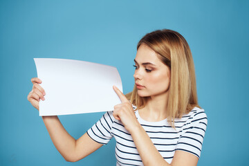 Wall Mural - Woman holding sheet of paper striped T-shirt Copy Space cropped view blue background