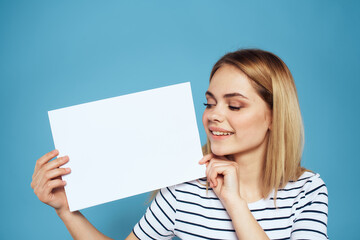 Canvas Print - Woman holding sheet of paper striped T-shirt Copy Space cropped view blue background