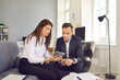 © Studio Romantic - Female secretary with digital tablet in hands shows electronic documents to her boss.